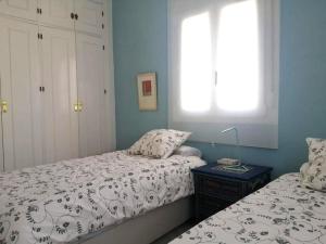 1 dormitorio con 2 camas y ventana en Chorrillo III, en Conil de la Frontera