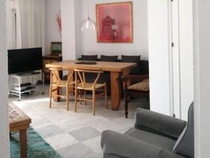 sala de estar con mesa de madera y sillas en Chorrillo III, en Conil de la Frontera