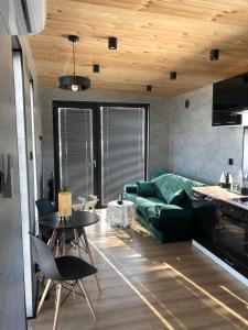 sala de estar con sofá verde y mesa en Green Hill Apartment - Domek na Wyłączność, en Leśnica