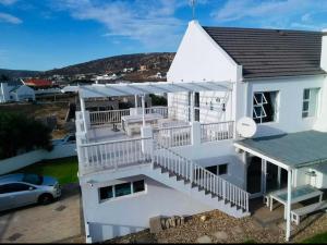 een wit huis met een balkon en een auto bij SHB Sonvanger in St Helena Bay