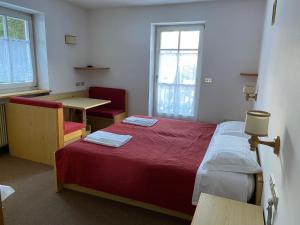 una camera con letto, tavolo e scrivania di Dolomites Hotel La Meridiana a Moena