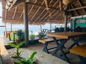 a picnic table on the beach with the ocean in the background at Backpack Beach Hostel & Reggae Bar in Galle