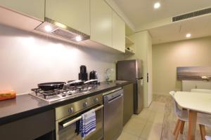 een keuken met een fornuis en een koelkast bij Rest Collins Tower collection in Melbourne