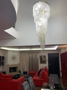a living room with red couches and a chandelier at Two Floor Luxurious Villa #skg in Thessaloniki