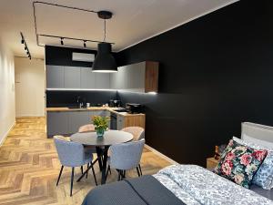 ein Zimmer mit Tisch und Stühlen und einer Küche in der Unterkunft Apartamenty Warowna 2 in Pless