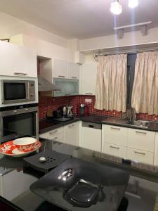 cocina con fregadero y microondas en Two Floor Luxurious Villa #skg, en Tesalónica