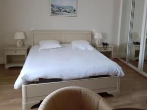 a bedroom with a white bed and two chairs at Hotel-Restaurant Domaine de la Grande Garenne in Neuvy-sur-Barangeon