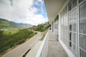 a balcony of a building with a view of a road at The Montfort, Nuwaraeliya in Nuwara Eliya