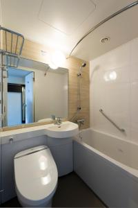 a bathroom with a toilet and a sink and a tub at Via Inn Nagoya Station Tsubaki-cho in Nagoya