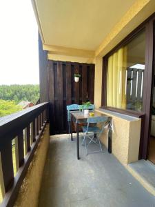 a patio with a table and chairs on a balcony at Laye station - les Arolles A - 4 personnes in Laye