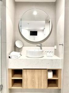 ein Bad mit einem Waschbecken und einem Spiegel in der Unterkunft 18OB Absolute Beachfront - Noosa Main Beach in Noosa Heads
