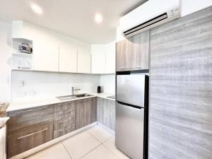 a kitchen with wooden cabinets and a refrigerator at 18OB - Absolute Beachfront - Noosa Main Beach in Noosa Heads