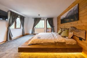 a bedroom with a large bed with a wooden headboard at Moșia Sofiei in Moieciu de Sus