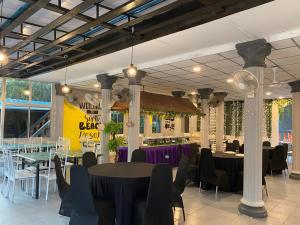 a dining room with tables and chairs in a building at SURIA BEACH RESORT Pangkor in Pangkor