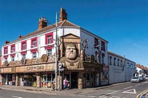 Un edificio con un león a un lado. en Resthaven Cottage, en Mablethorpe