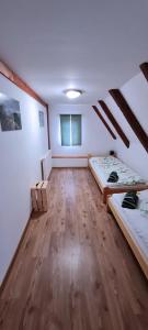 Pokój na poddaszu z 2 łóżkami i drewnianą podłogą w obiekcie Wellness Chaloupka Mezná - Národní park České Švýcarsko w mieście Hřensko