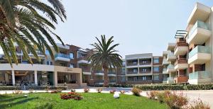 a large building with palm trees in front of it at Elysion Hotel in Mytilini