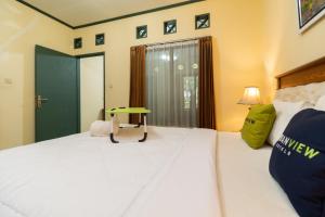 Ein Bett oder Betten in einem Zimmer der Unterkunft Urbanview Hotel Griya Astoeti 2 Cisarua Puncak