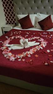 a bed with a heart made out of flower petals at Hotel Kamanga in Tomar