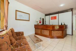 a waiting room with a couch and a desk at Urbanview Hotel Griya Astoeti 2 Cisarua Puncak in Kopo 2