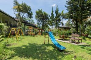 einen Spielplatz im Garten mit Rutsche und Bank in der Unterkunft Urbanview Hotel Griya Astoeti 2 Cisarua Puncak in Kopo 2