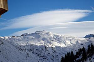a cloud over a snow covered mountain with trees at Munk - Avoriaz in Avoriaz