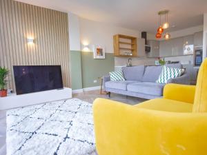 a living room with a couch and a tv at Garden Apartment Winchester in Winchester