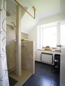baño con ducha, lavabo y ventana en Ferienhaus Laux en Weiskirchen