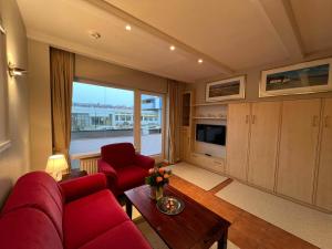 a living room with red furniture and a large window at Robbe in Westerland