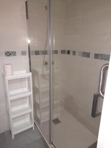 La salle de bains est pourvue d'une douche avec une porte en verre. dans l'établissement Hospedaje Benacazon A49, à Benacazón