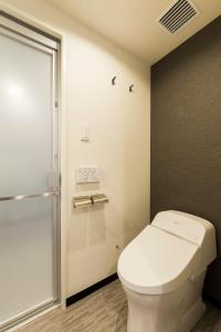 a bathroom with a toilet and a shower at Via Inn Nagoya Station Tsubaki-cho in Nagoya