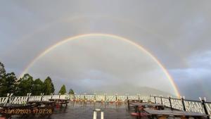 仁愛鄉的住宿－清境娜嚕彎民宿，天空中的彩虹,带野餐桌和长凳
