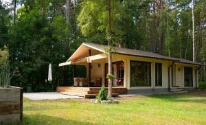 a small yellow cottage in the middle of a yard at Ruhnu Holiday House in Ruhnu