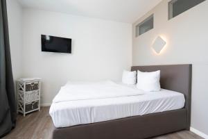 シャルボイツにあるFerienwohnung Capolino Suiteのベッドルーム(白いシーツ付きのベッド、テレビ付)