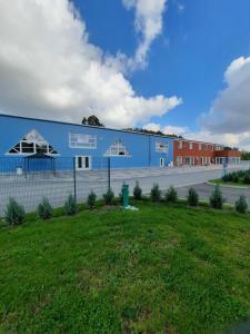 un gran edificio azul con un campo delante en Wohnung "Wolgast", en Gützkow