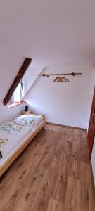 sypialnia z łóżkiem i drewnianą podłogą w obiekcie Wellness Chaloupka Mezná - Národní park České Švýcarsko w mieście Hřensko