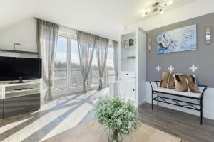 sala de estar con TV y ventana en Ferienwohnung Die 25 en Timmendorfer Strand