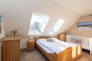 a bedroom with a wooden bed and two windows at Ferienwohnung Die 25 in Timmendorfer Strand