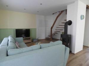 sala de estar con sofá azul y TV en komfortables Ferienhaus Allee, en Krummin