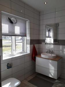 y baño con lavabo, aseo y espejo. en komfortables Ferienhaus Allee, en Krummin