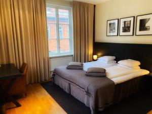 een slaapkamer met een bed met 2 kussens erop bij Hotel Villan in Göteborg