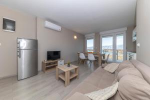 Una sala de estar con un sofá, un refrigerador y una mesa. en Isola Bella Croazia - C4, en Povljana