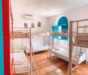 ein Zimmer mit einem Haufen Etagenbetten in der Unterkunft Sevilla Kitsch Hostel Art in Sevilla