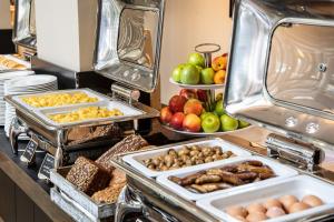 a buffet with different types of food on a counter at INNSiDE by Meliá Dresden in Dresden