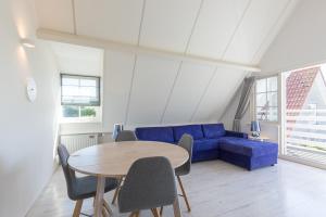 a living room with a blue couch and a table at Hello Zeeland - Appartement Brouwerijweg 43-1 in Domburg