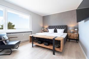 ein Schlafzimmer mit einem großen Bett und einem Stuhl in der Unterkunft Ferienwohnung Puro Suite in Scharbeutz