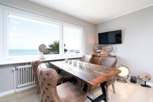 ein Esszimmer mit einem Tisch, Stühlen und einem Fenster in der Unterkunft Ferienwohnung Puro Suite in Scharbeutz
