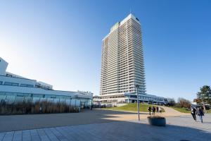 トラフェミュンデにあるFerienwohnung Nordermoleの目の前を歩く人々のいる高い建物