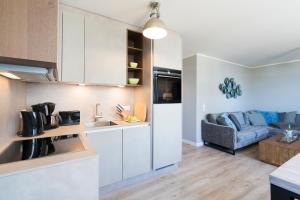 eine Küche und ein Wohnzimmer mit einem Sofa in der Unterkunft Ferienwohnung Puro in Scharbeutz