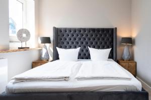 Schlafzimmer mit einem großen Bett mit einem schwarzen Kopfteil in der Unterkunft Ferienwohnung Puro in Scharbeutz